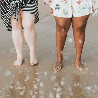 beach scene showing two people's lower legs and feet
